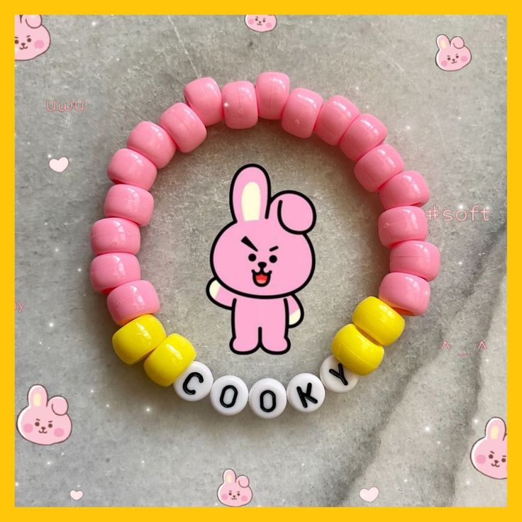 a pink and yellow bracelet with an image of a bunny in the middle on it