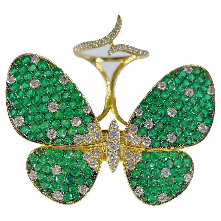 Featuring a playful butterfly motif set with round cut diamonds and green sapphires, Amwaj charming ring captures the beauty of butterfly wings created in shining rows of diamonds and sapphires set in 18 karat yellow gold, each of stone has been independently cut to fit the curvy design. 18 Karat Yellow Gold Gold Weight: 21.50 Gr Diamond: 1,72 Cts Tsavorite: 6.26 Cts Ring Size: 54, 49, 6.25 Color and clarity: H, VS