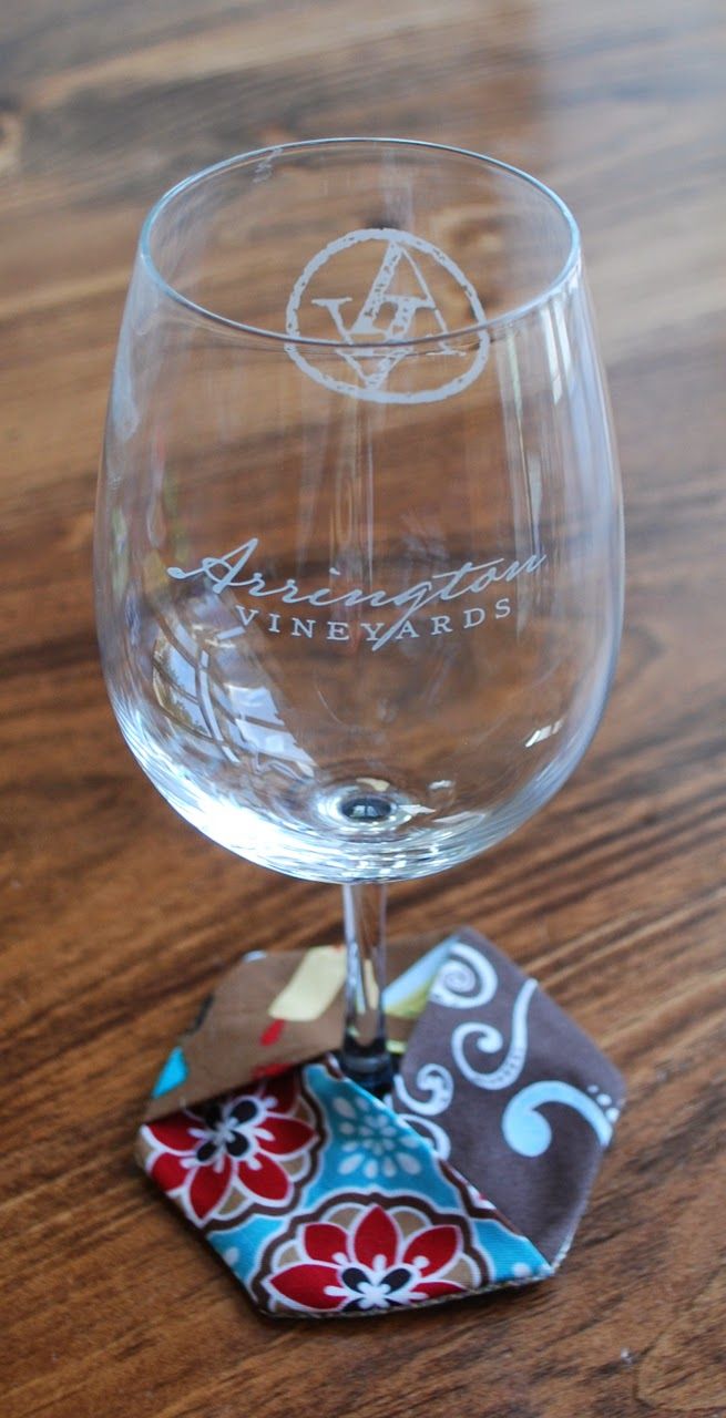 an empty wine glass sitting on top of a wooden table next to a small napkin