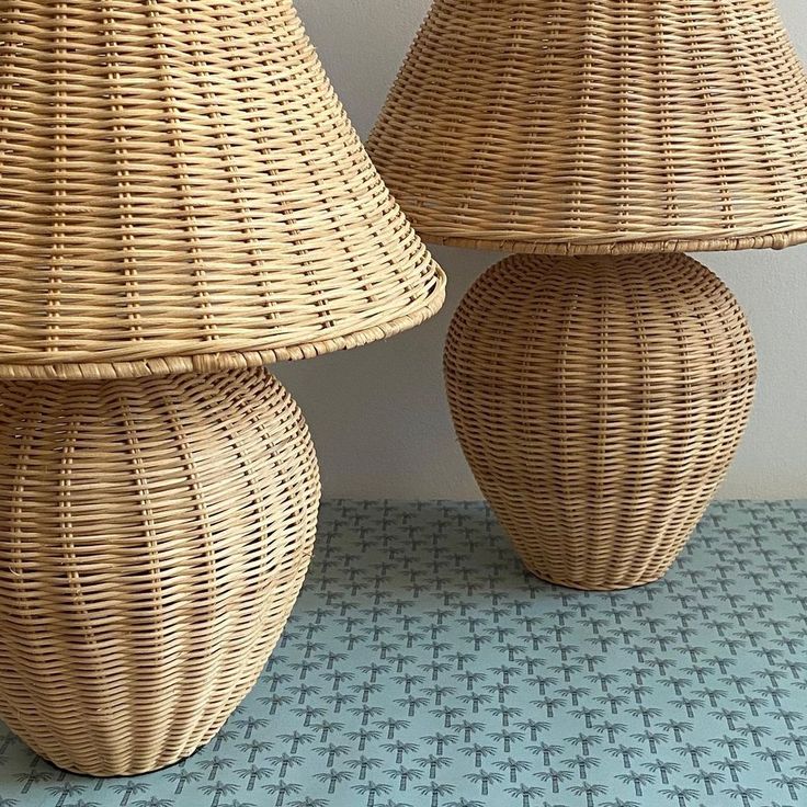 two wicker lamps sitting next to each other on a blue and white tiled floor