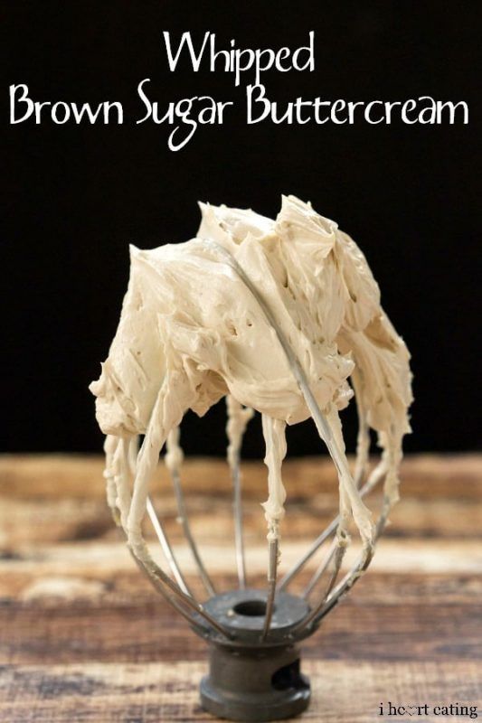 a whisk filled with cream sitting on top of a wooden table