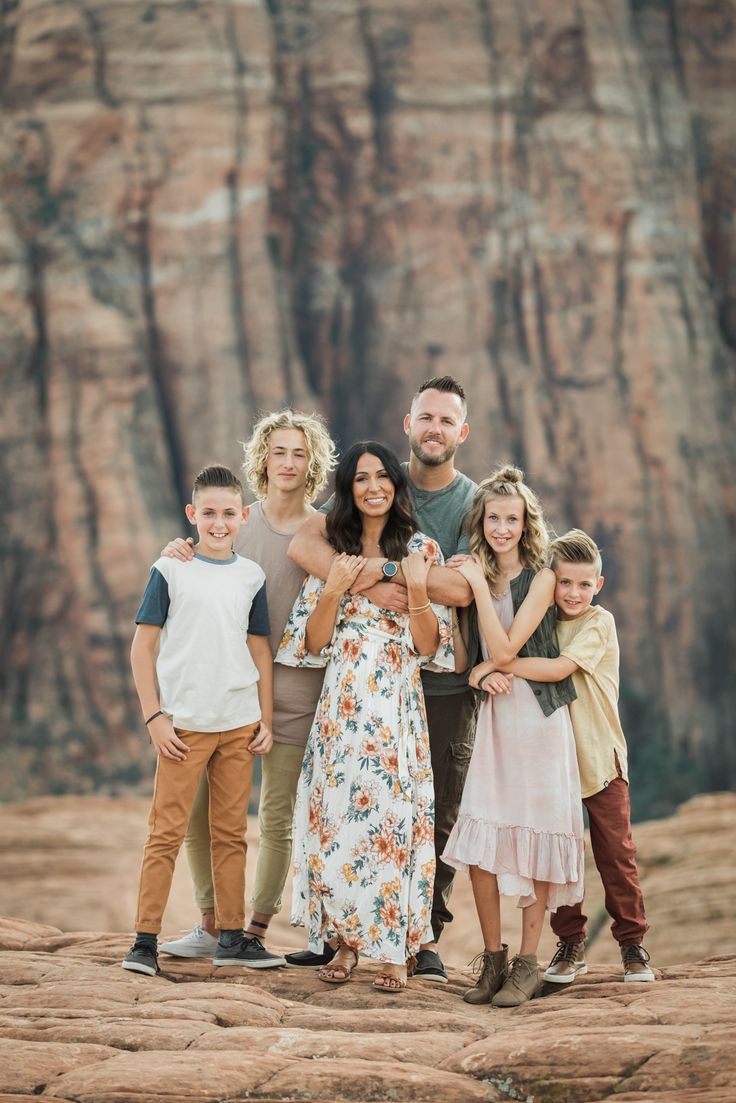 a family posing for a photo in front of a mountain range with their arms around each other