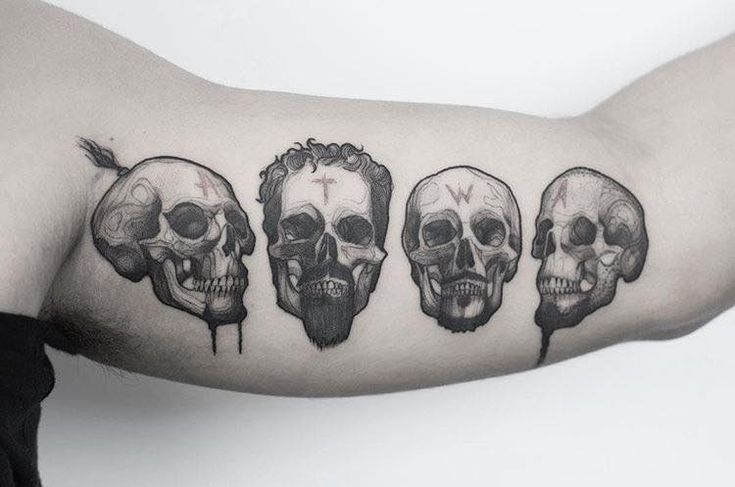 a man's arm with three skulls on it