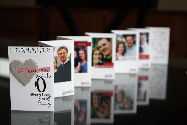 a table topped with cards and pictures on top of each other next to a candle