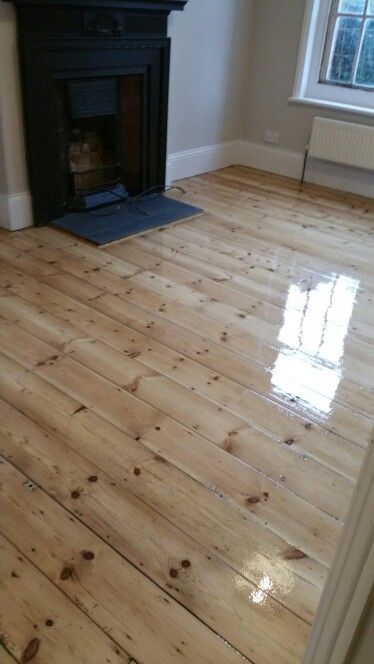 an empty room with wood floors and a fire place