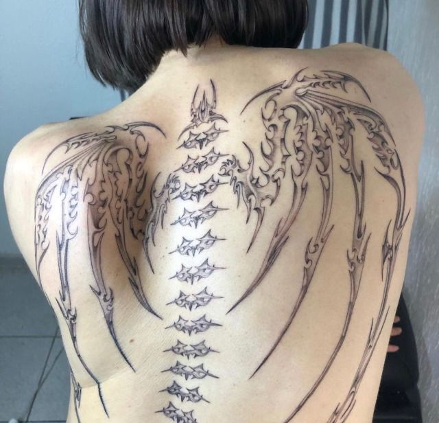 the back of a woman with tattoos on her body