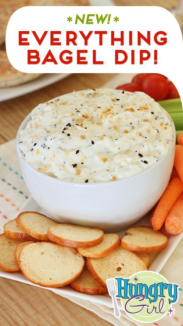 a bowl of dip surrounded by crackers and carrots on a plate with the words, everything bagel dip