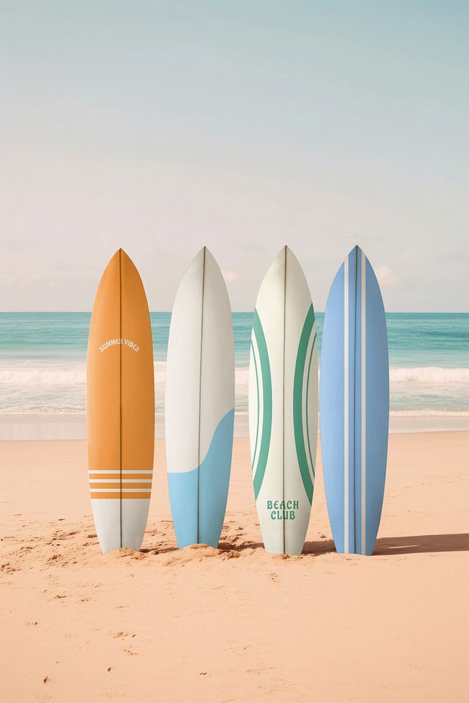 four surfboards are lined up on the sand at the beach in front of the ocean