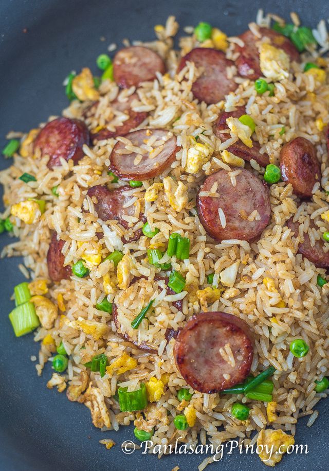 a plate with rice, sausage and peas on it