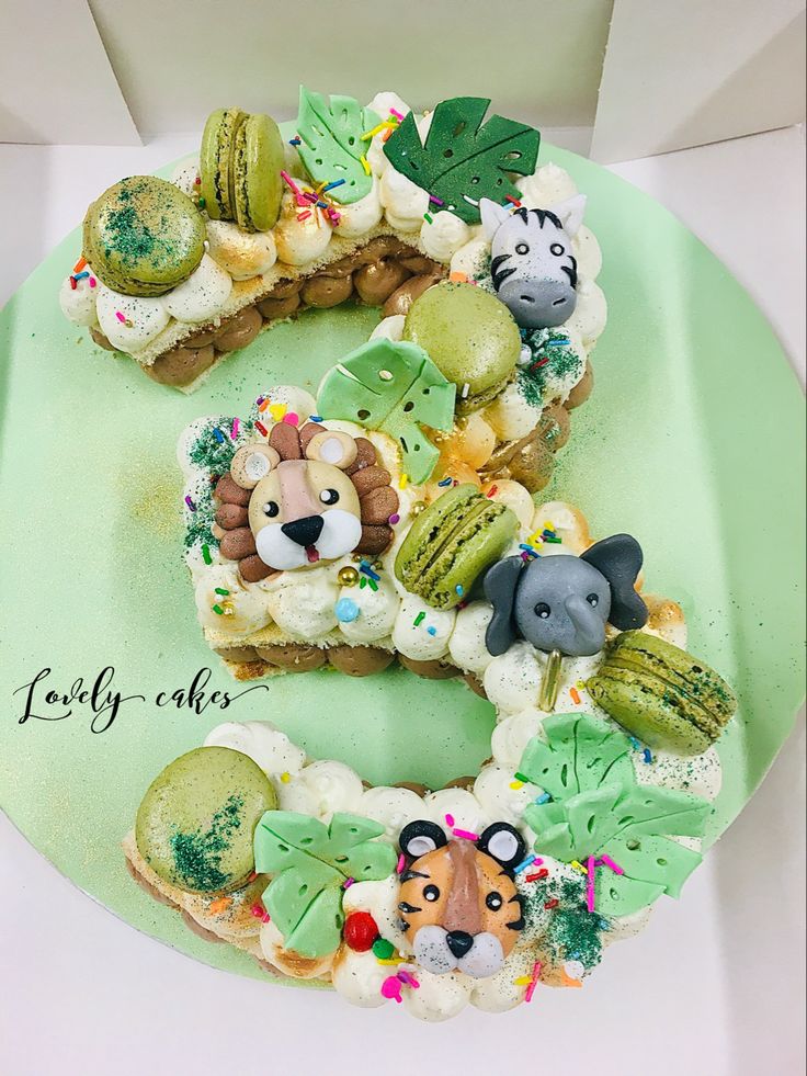 a cake shaped like the number five with animals and plants on it's side