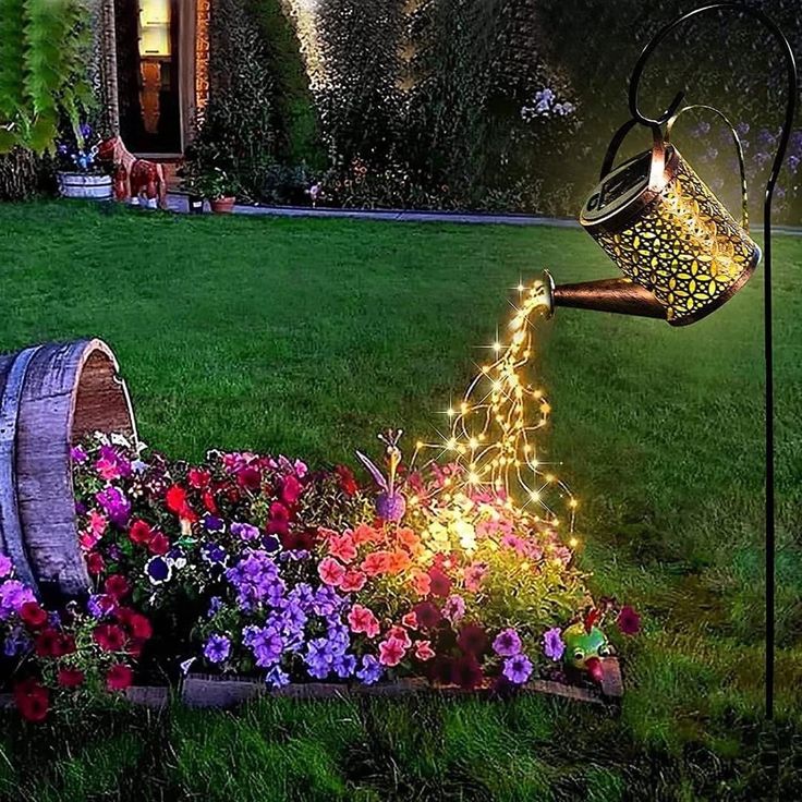 a watering can filled with flowers in the grass