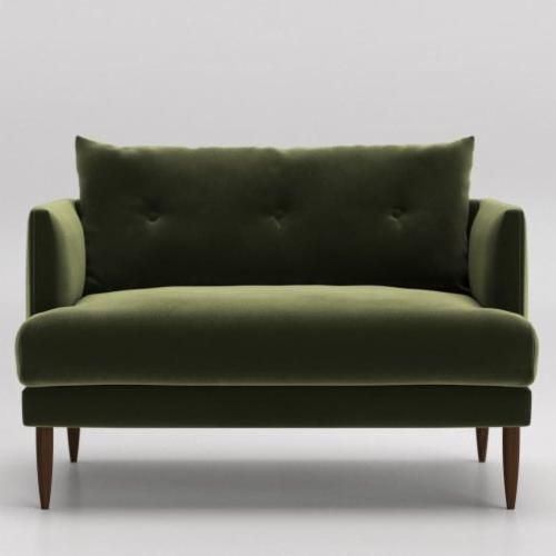 a green couch sitting on top of a white floor