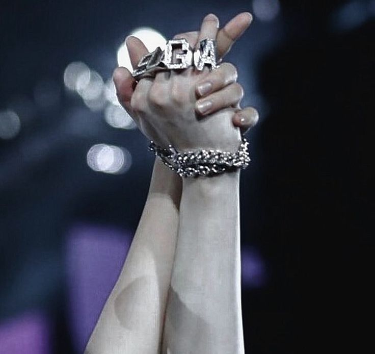 two hands holding up the word love in front of a microphone with lights behind them