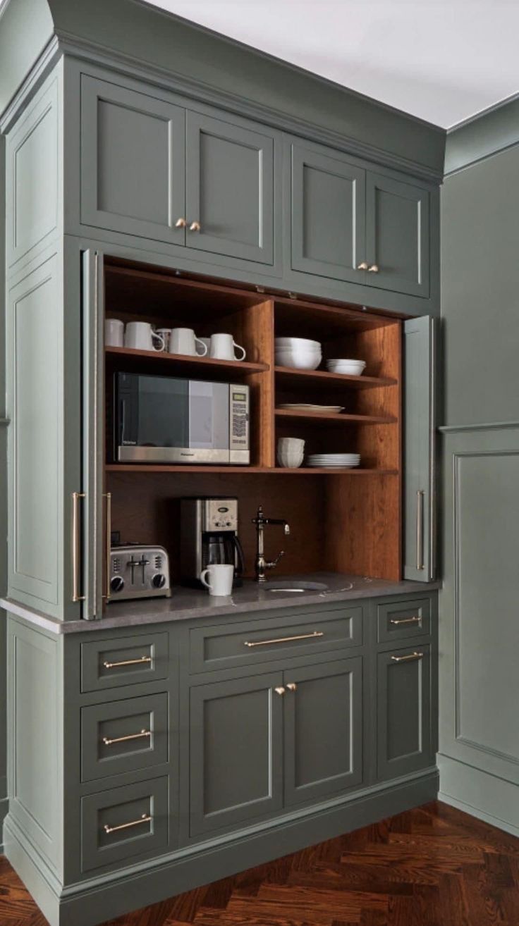 a kitchen with gray cabinets and wooden floors