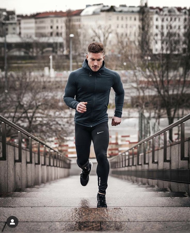 a man is running down the stairs in his black and grey outfit with no shoes