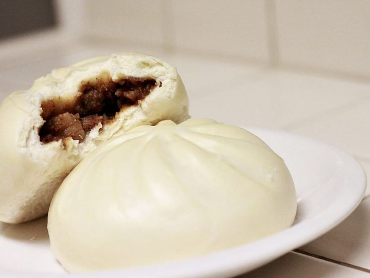 two dumplings sitting on a white plate