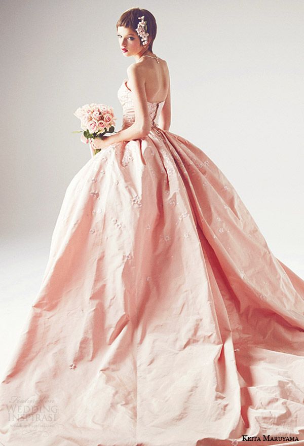 a woman in a pink wedding dress holding a bouquet and looking off to the side