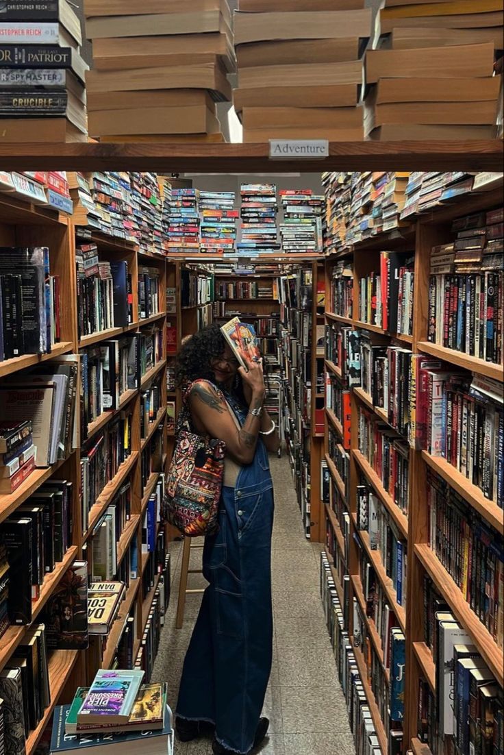 a woman is standing in the aisle of a book store with many books on shelves