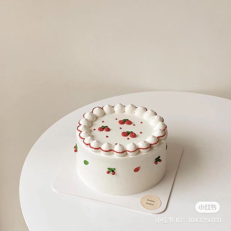 a small white cake sitting on top of a table next to a cupcake tin