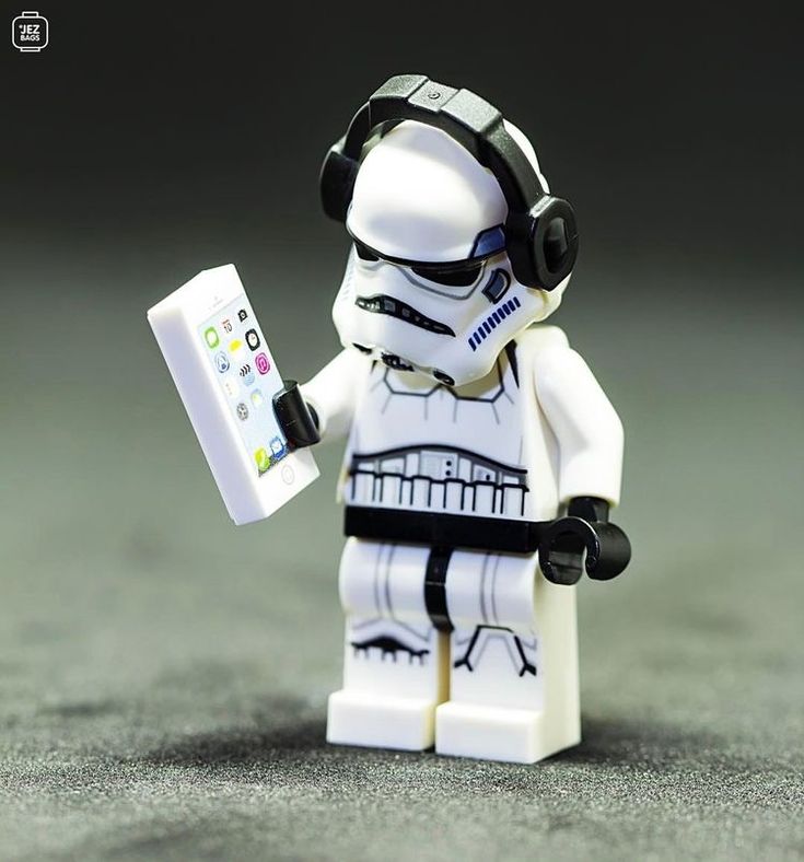 a lego star wars character is holding a remote control in one hand and wearing headphones on the other