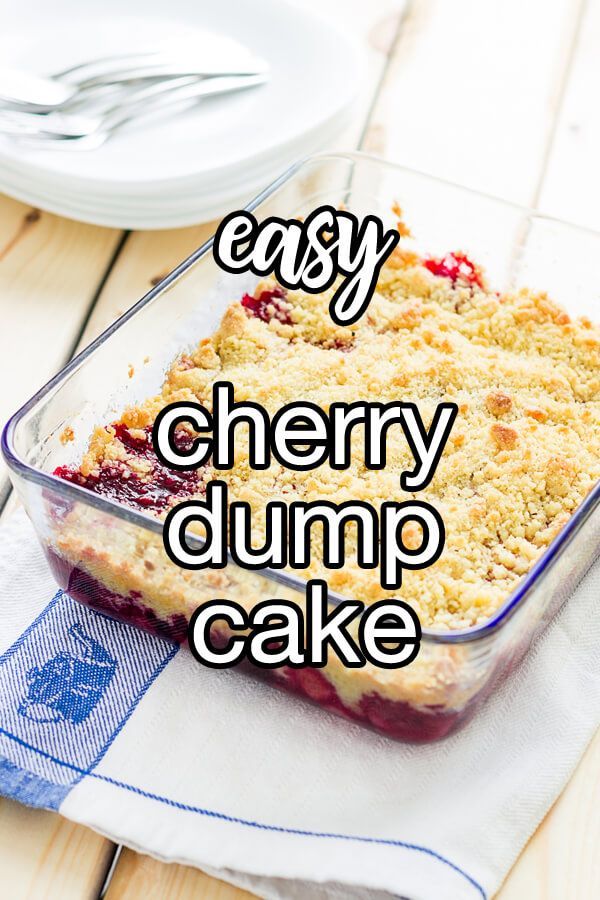 an easy cherry dump cake in a glass baking dish on a wooden table with the words easy cherry dump cake above it