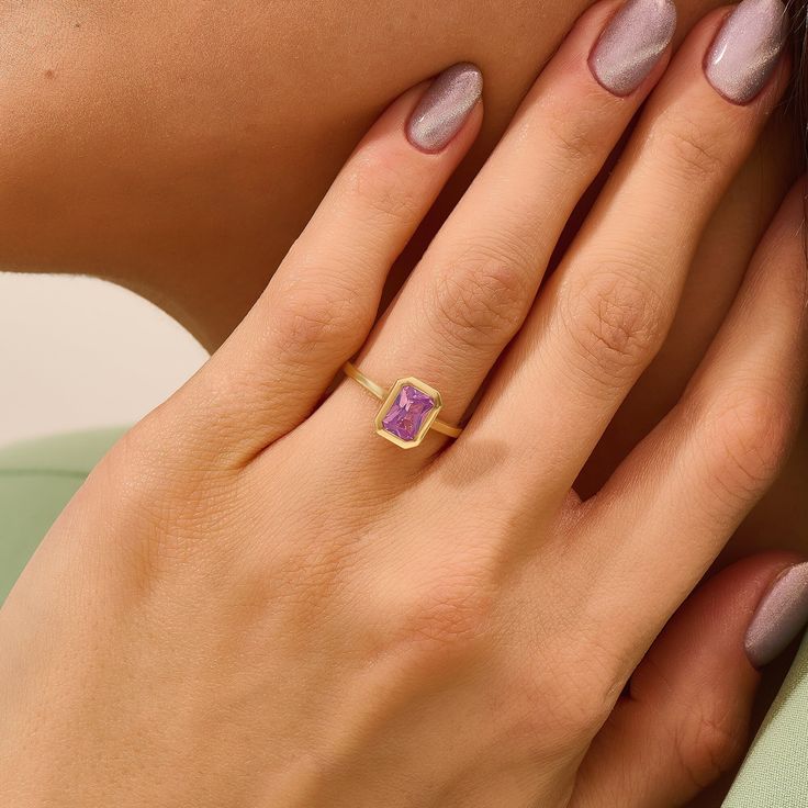 Lavender Chalcedony Bezel Engagement Ring, this engagement ring boasts an emerald-cut solitaire design, showcasing the exquisite beauty of the purple gemstone. Crafted in solid gold, it serves as a timeless symbol of love and commitment. Ideal for anniversaries or as a thoughtful gift, this ring is a celebration of romance and sophistication. Embrace the charm of the gemstone and the warmth of solid gold with this stunning piece, making it a cherished addition to your fine jewelry collection. Emerald Cut Birthstone Ring With Accent Stones, Emerald Cut Lavender Jewelry For Anniversary, Lavender Emerald Cut Jewelry For Anniversary, Lavender Emerald Cut Fine Jewelry Ring, Purple Radiant Cut Anniversary Ring, Emerald Promise Ring With Rectangular Stone, Radiant Cut Purple Ring For Anniversary, Purple Radiant Cut Ring For Anniversary, Radiant Cut Purple Anniversary Ring