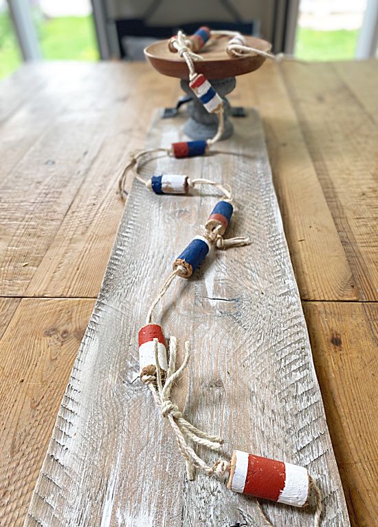 a long wooden table topped with two small boats on it's sides and rope