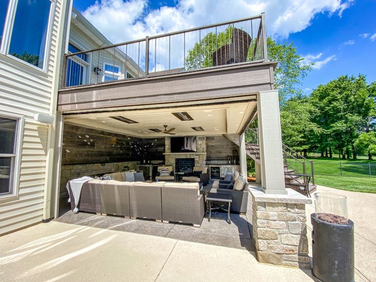 an outdoor living area with patio furniture under a covered deck and stairs leading up to the second floor