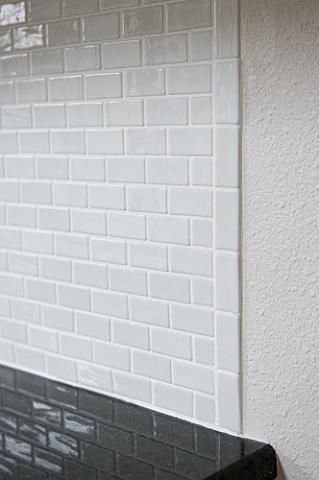 a black and white tiled counter top next to a wall