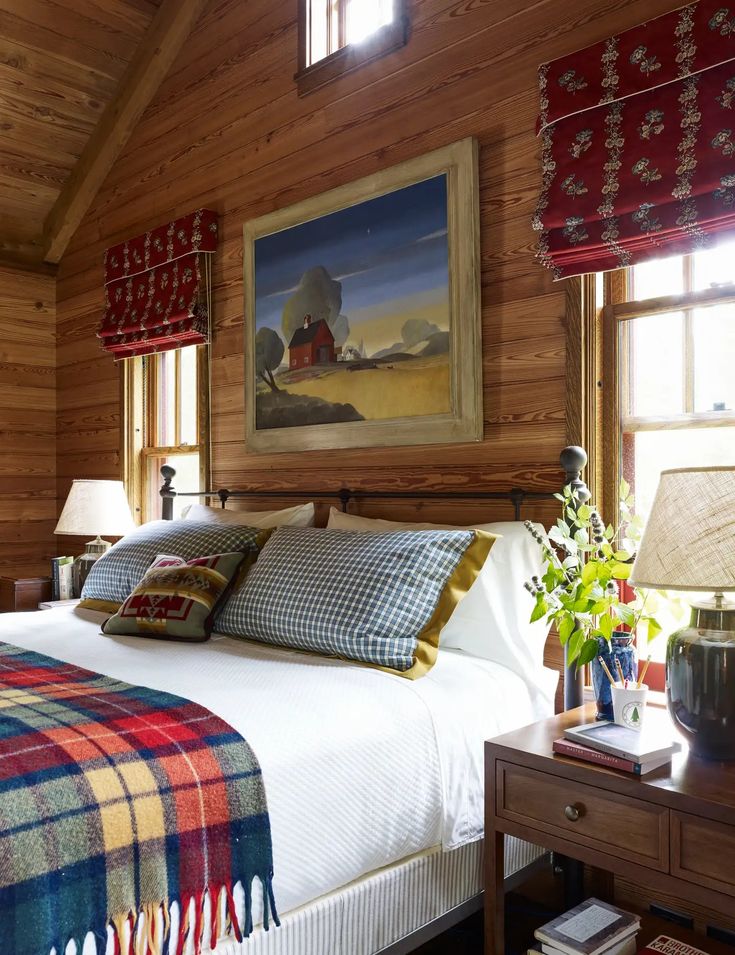 a bed in a bedroom with wooden walls and ceilinging, along with two lamps on either side of the bed