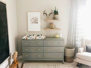 a baby's room with a dresser, bookshelf and pictures on the wall