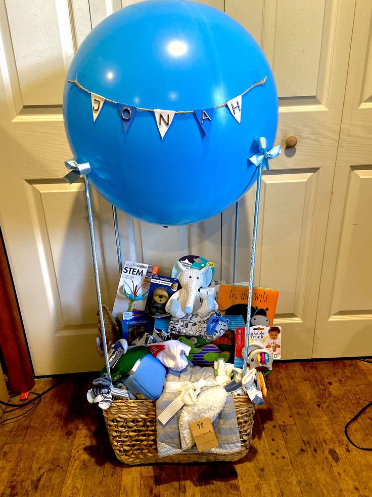 a blue balloon sitting on top of a wooden floor next to a basket filled with items