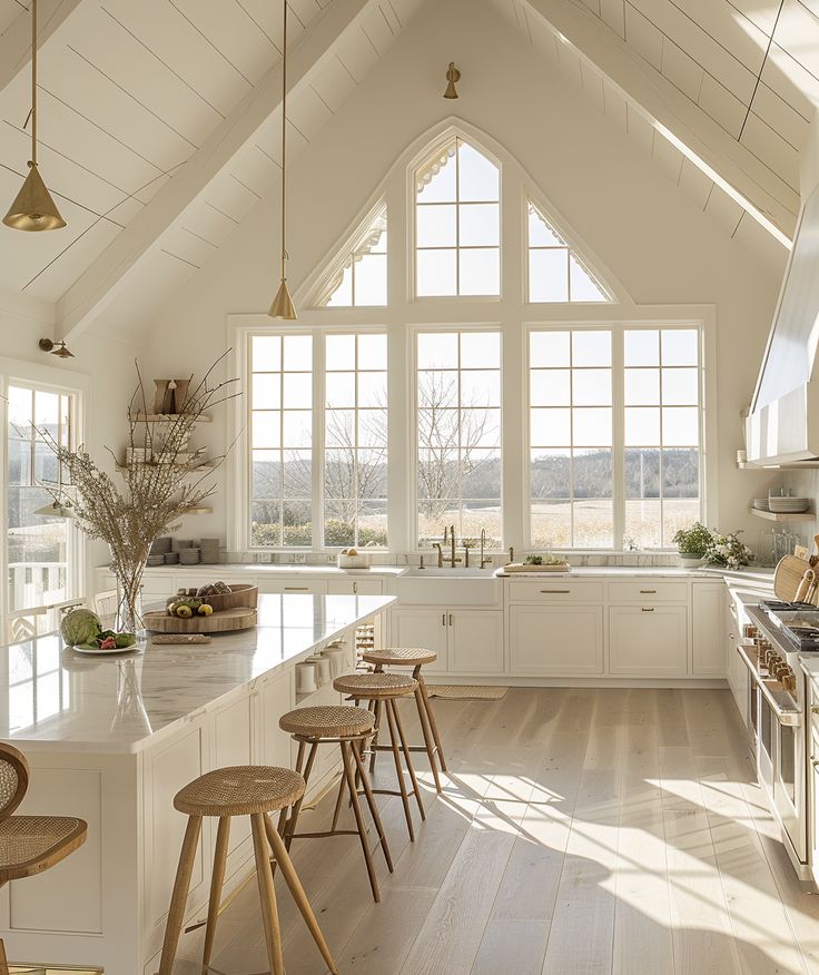 a large kitchen with white cabinets and wooden stools