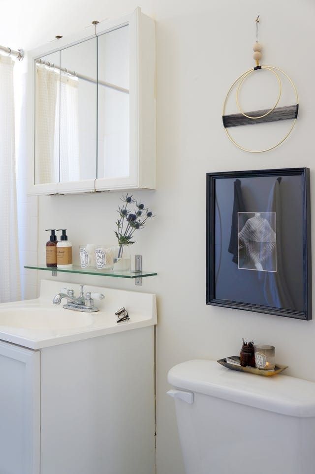 a bathroom with a sink, toilet and mirror above the sink is decorated in black and white