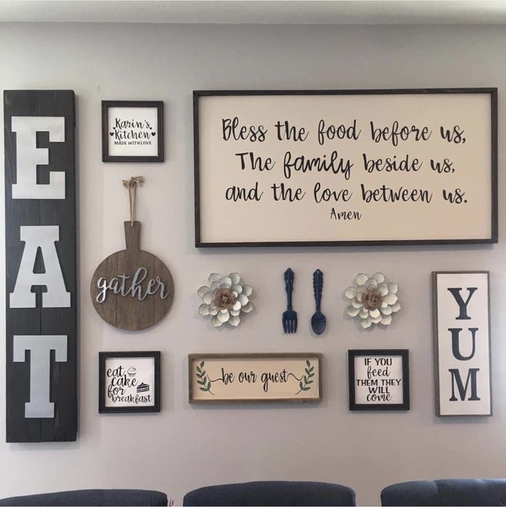 a wall filled with framed pictures and other items on top of a white wall next to blue chairs