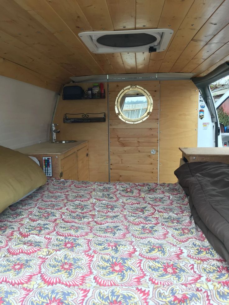 the inside of a camper with a bed and window