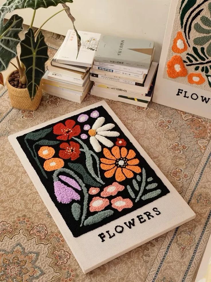 there is a flower rug on the floor next to books and a potted plant