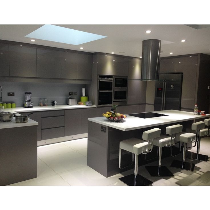 an image of a modern kitchen setting with stainless steel appliances and bar stools in the center