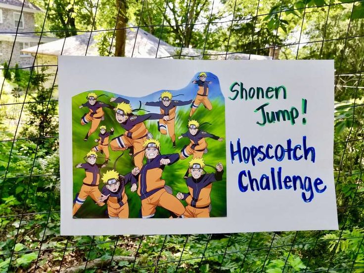 a sign is hanging on a fence in front of some trees and bushes with cartoon characters