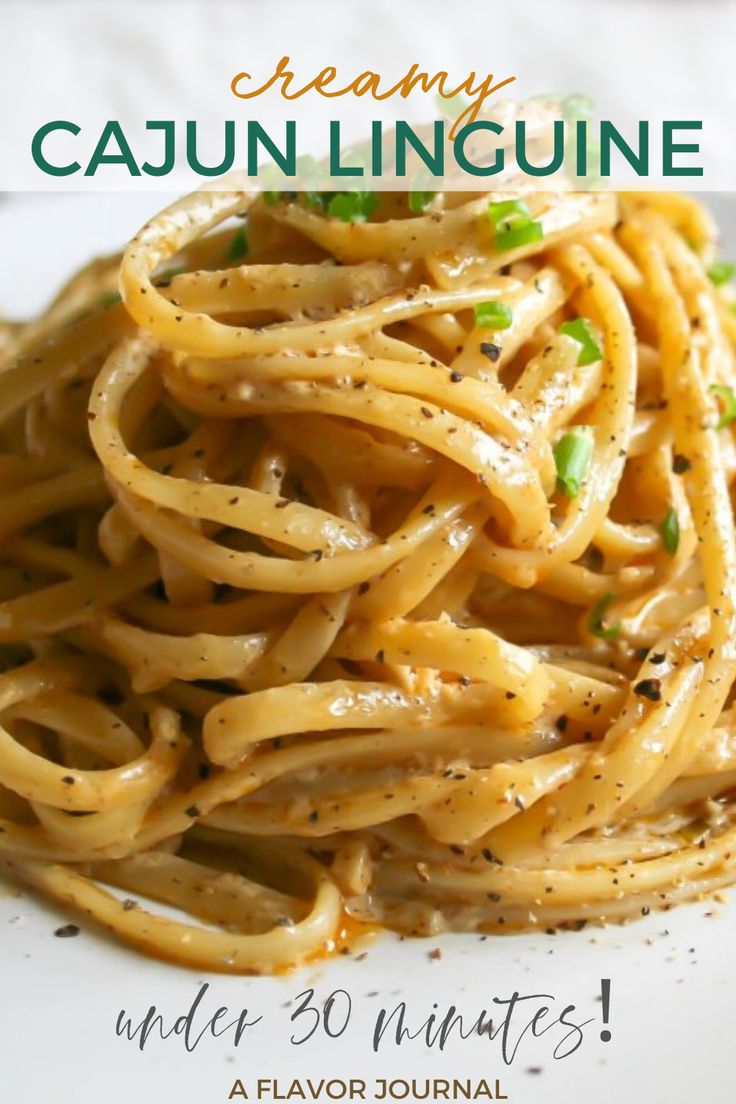 a white plate topped with pasta covered in parmesan cheese and green onion garnish