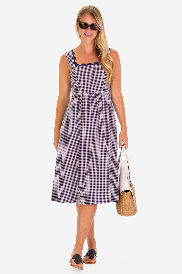 The RicRac Wendy dress is the perfect pop of spring, ready to take you to the farmers market, brunch, and a sunny shopping day FEEL: The classic Navy Gingham is a woven fabric that is breathable yet will withstand many seasons of wear. (50% polyester, 50% cotton) FAVORITE FEATURES: Scallop neckline detail Midi length Thick tank strap-bra friendly! Sweet Gingham Cotton Dress, Spring Gingham A-line Dress, Spring Gingham Plaid Dress With V-neck, Gingham V-neck Dress With Ruffles, Wendy Dress, Spring V-neck Plaid Gingham Dress, Navy Gingham, Bra Straps, Shopping Day