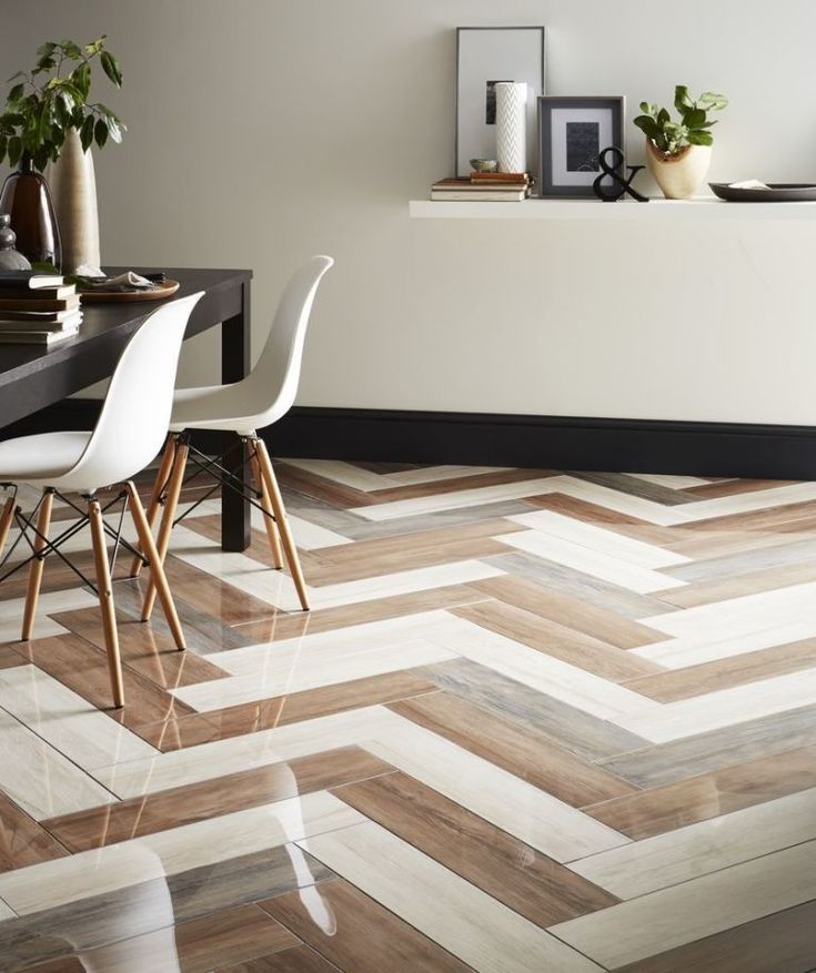 a dining room with white chairs and wood flooring that looks like chevron herringbones