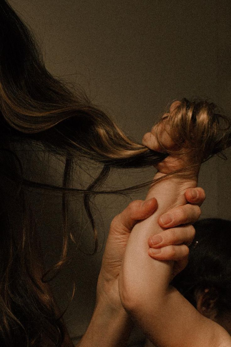 a woman is holding her hair in the air