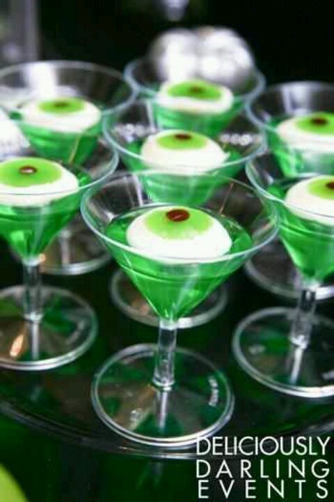 several martini glasses filled with green drinks