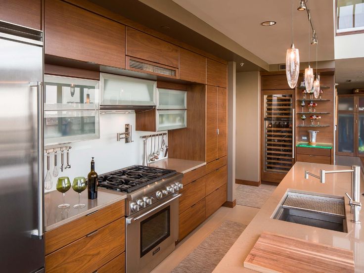 a modern kitchen with stainless steel appliances and wooden cabinets