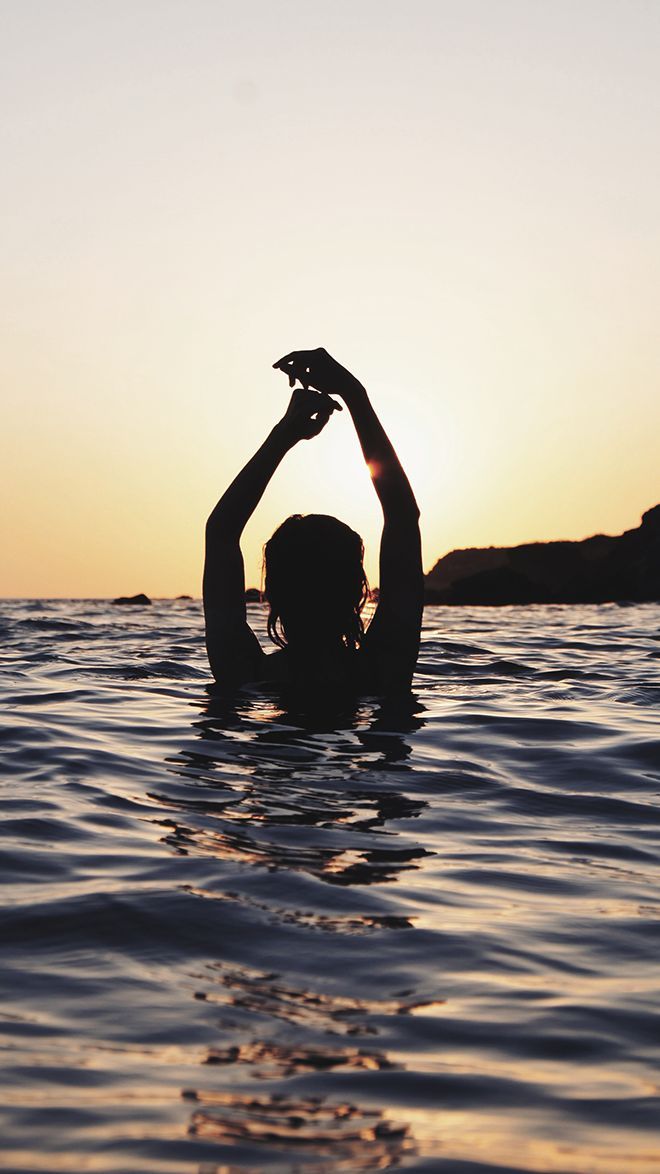 a person in the water with their hands up