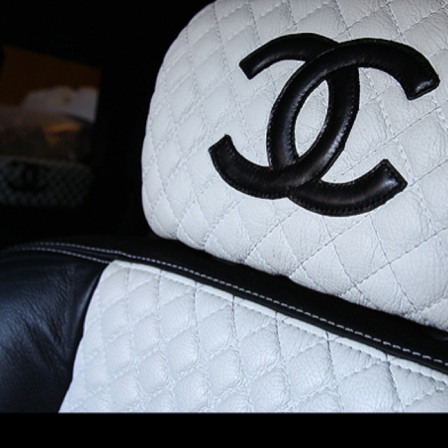 a chanel bag sitting on top of a black leather chair