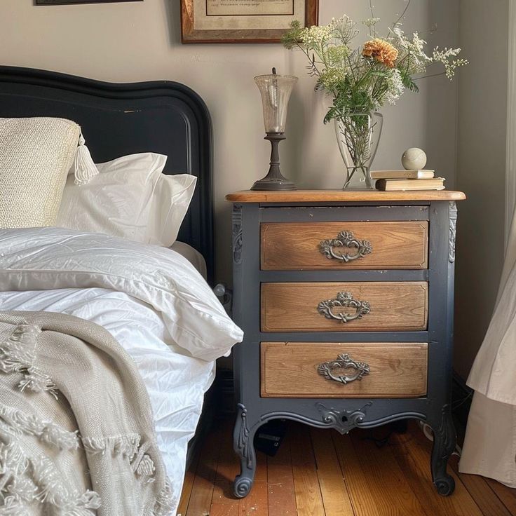 a bed room with a neatly made bed and a vase on top of the dresser