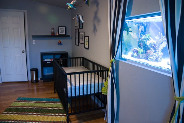 a baby's room with a fish tank in the corner