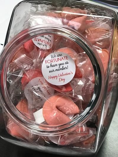 a plastic container filled with candies and valentine's day tag on top of it